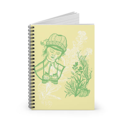 A female biologist with binoculars looks at plants sketched in green ink on a tan cover. The image is underlaid with a white flower watermark. The book is spiral bound. 